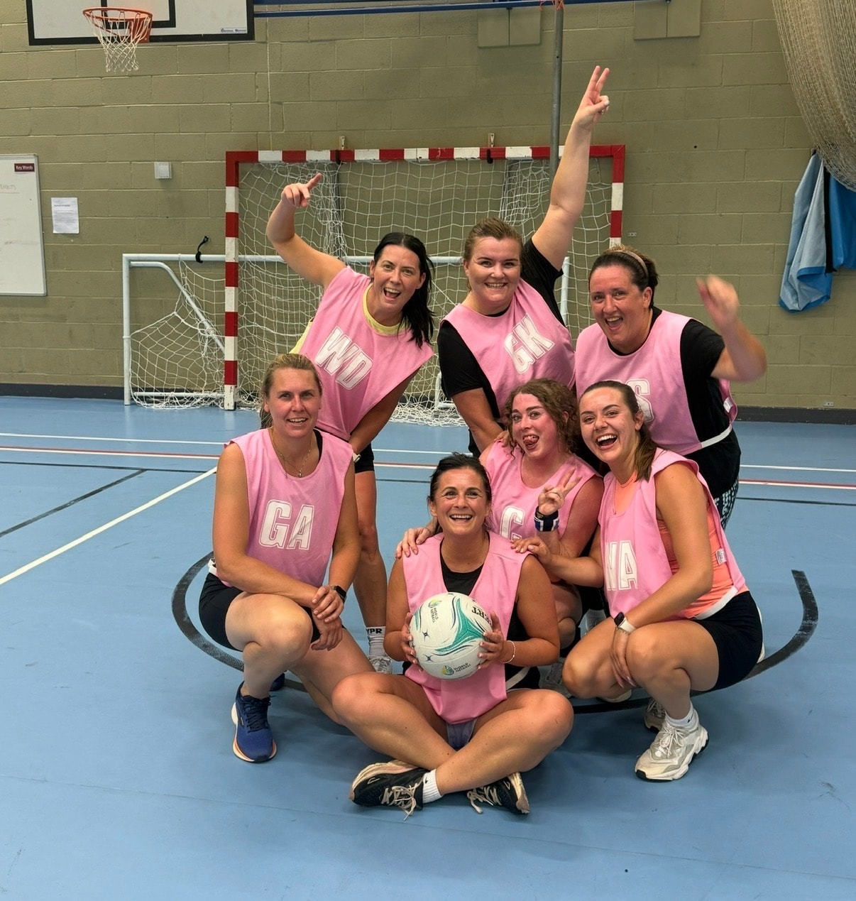Women's netball team celebrating indoors