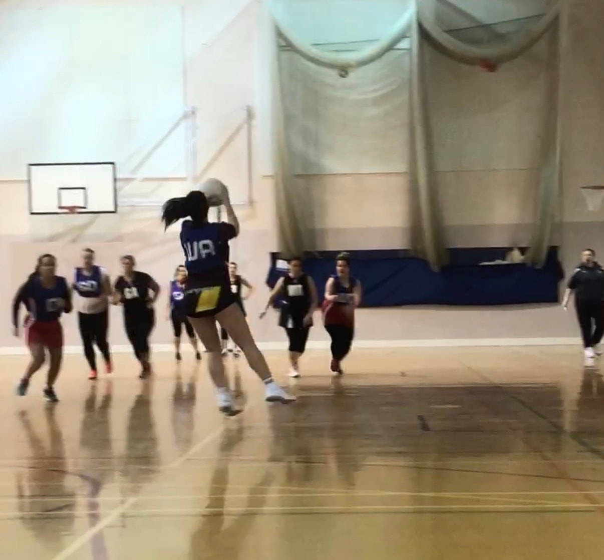 Basketball player shooting in indoor gym