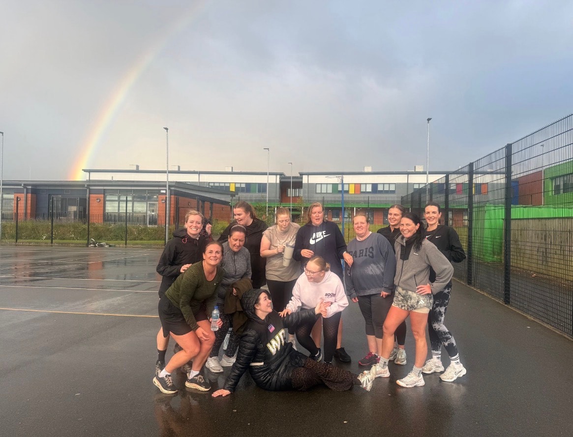 Group of runners posing on wet court rainbow